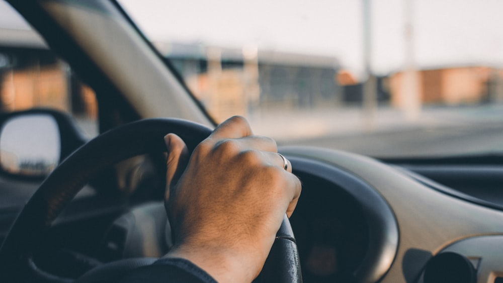 Person in schwarzem Langarmhemd fährt Auto