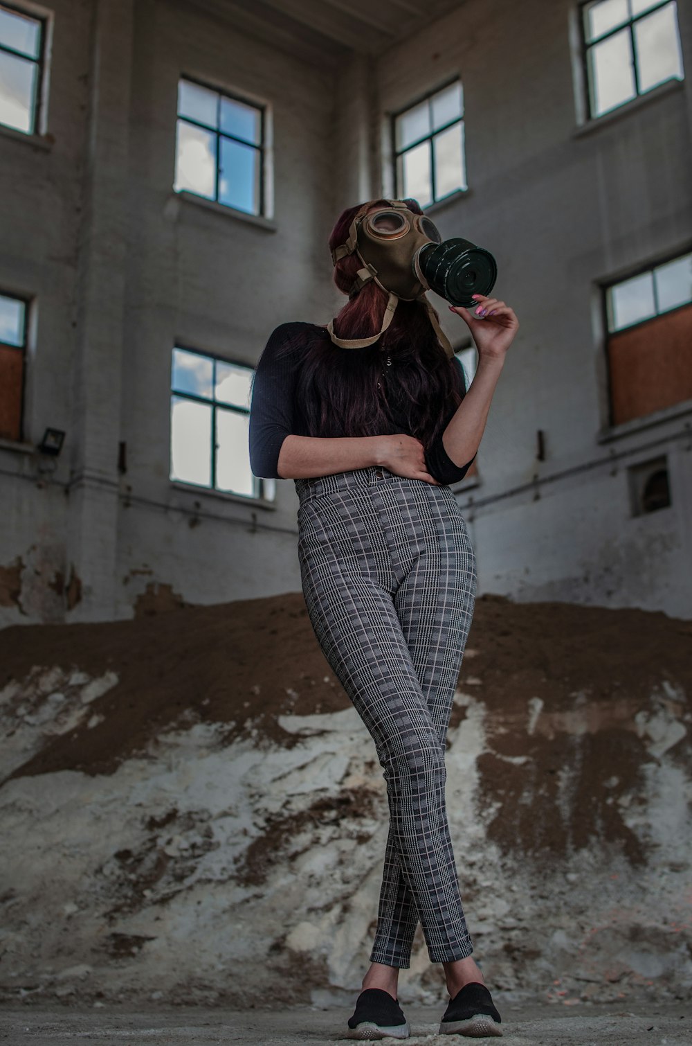 woman in blue long sleeve shirt and gray pants holding black dslr camera