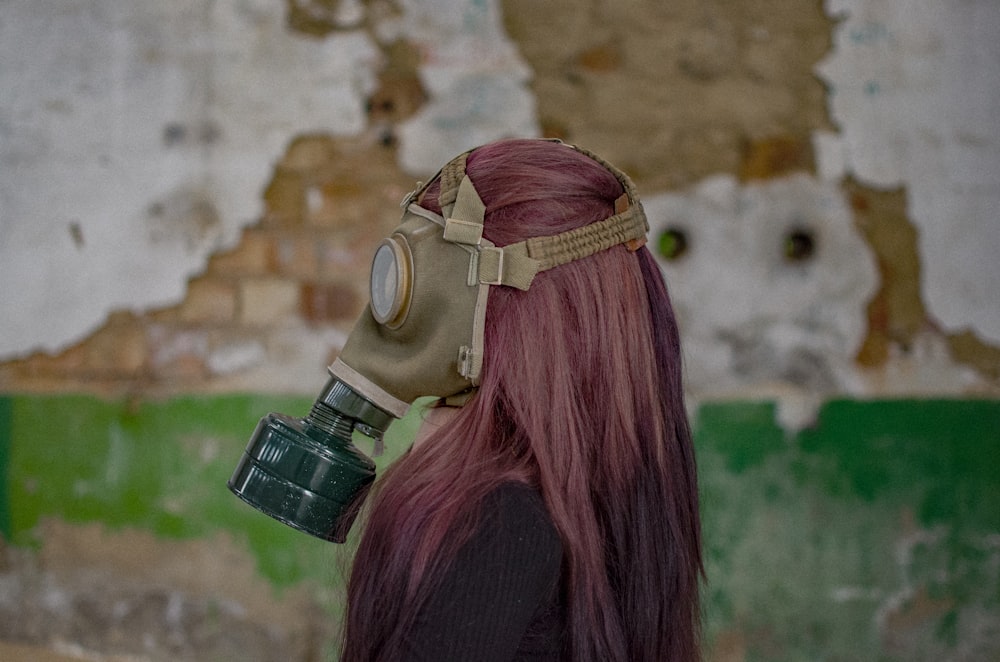 Femme aux cheveux roux portant un masque à gaz
