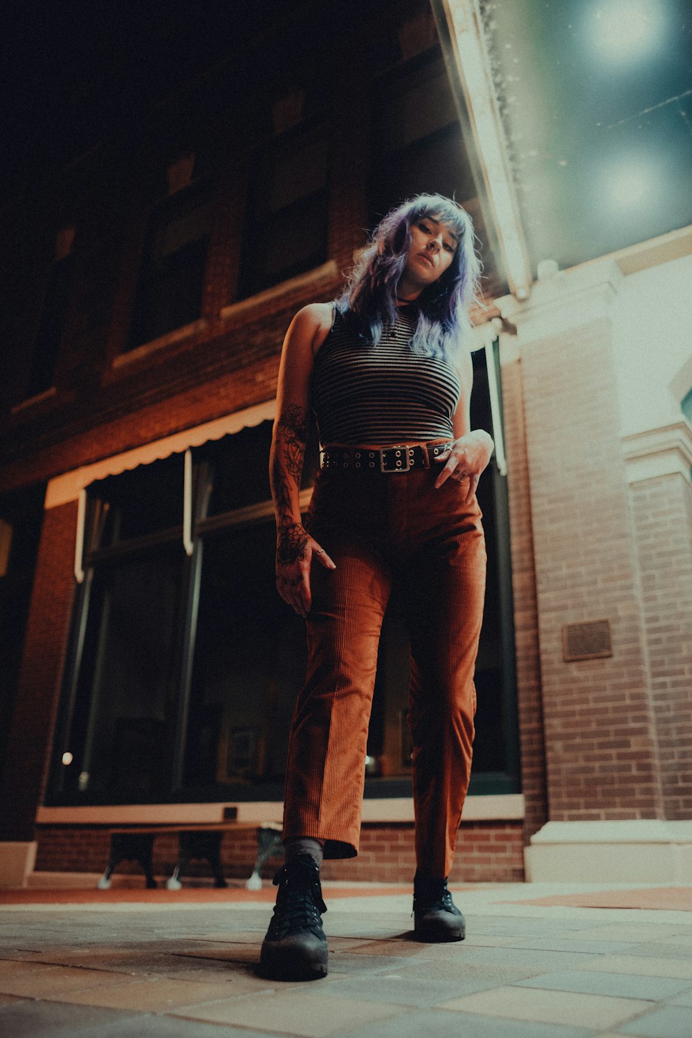 woman in black tank top and brown pants standing beside brown wooden door