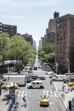cars on road near high rise buildings during daytime