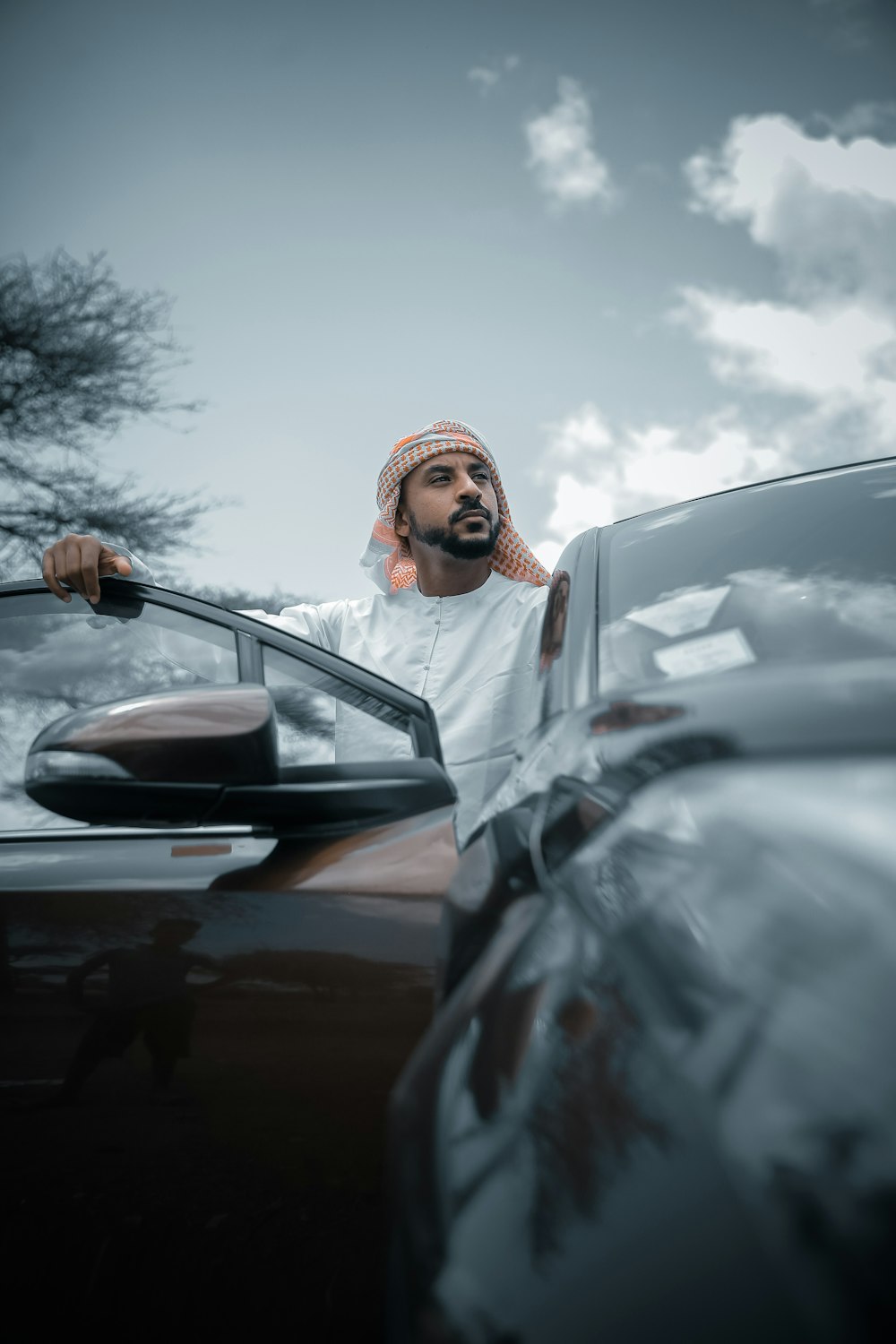 man in white thobe standing beside car during daytime