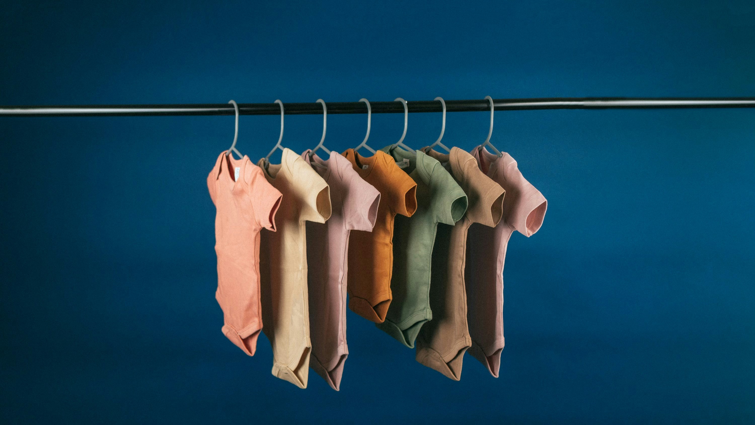 Soft cotton baby onesie set in pastel colors on white surface bright lighting
