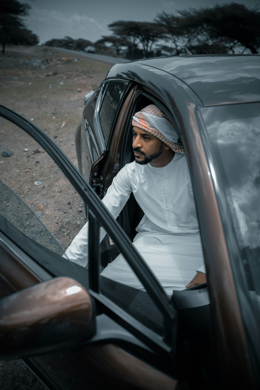 femme en hijab blanc assis sur la voiture