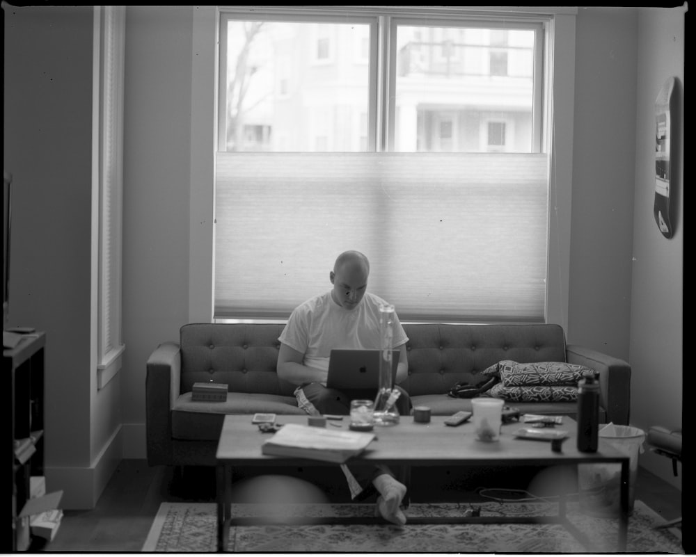 man in white dress shirt sitting on couch