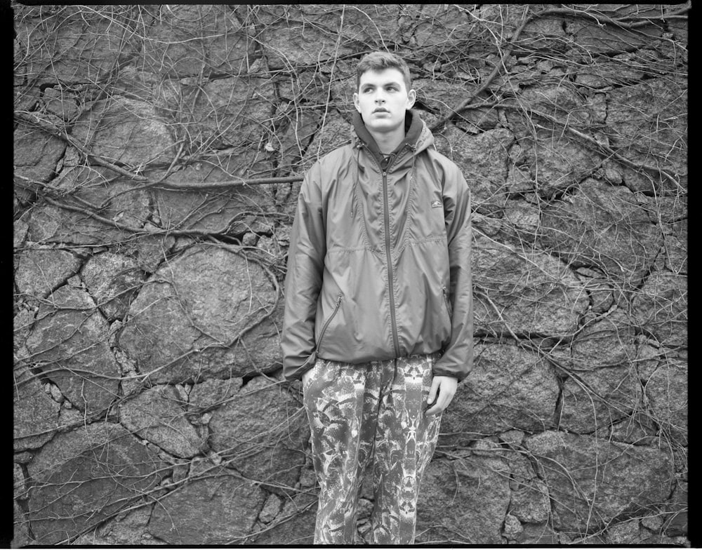 man in long sleeve shirt standing in grayscale photography