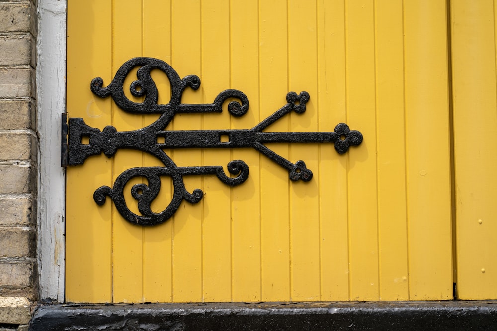 Un objeto de metal negro en una pared amarilla