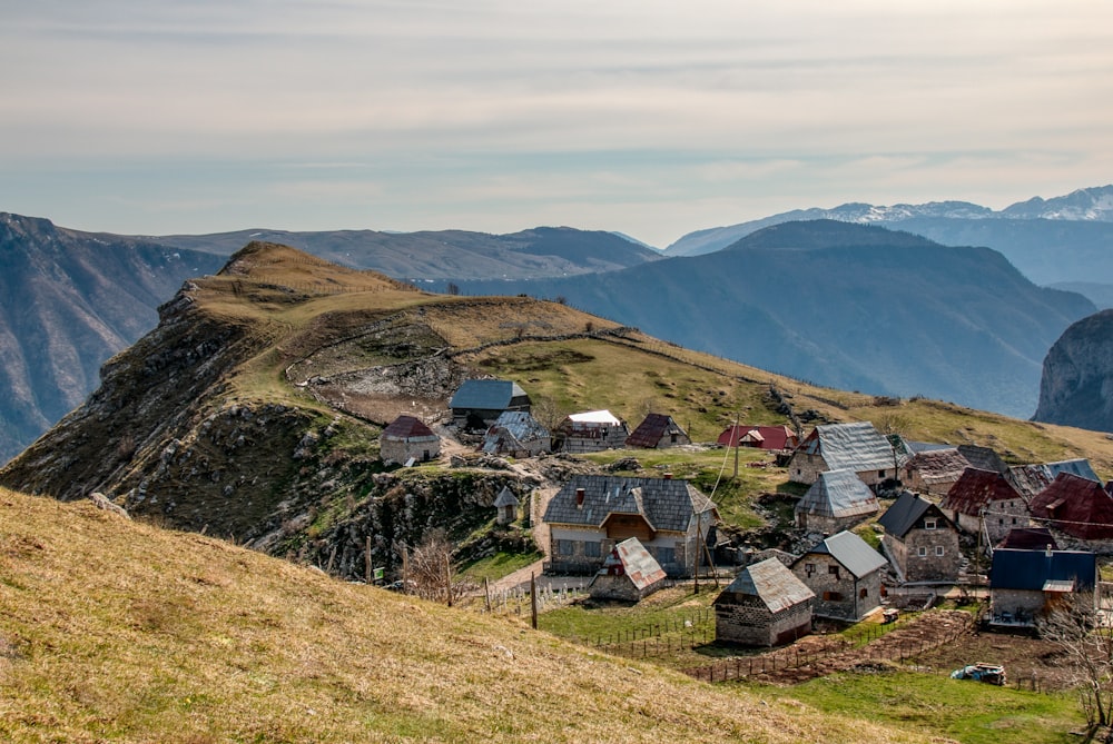 Un piccolo villaggio su una collina con le montagne sullo sfondo