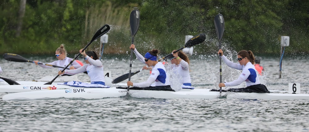 people riding on white kayak on lake during daytime