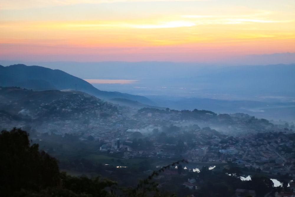 a view of a city from a hill at sunset