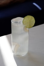 a glass of water with a lime slice on the rim