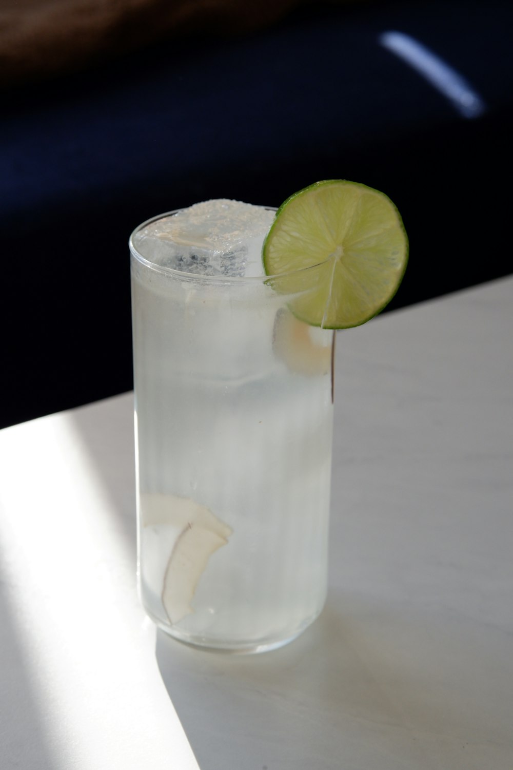 a glass of water with a lime slice on the rim