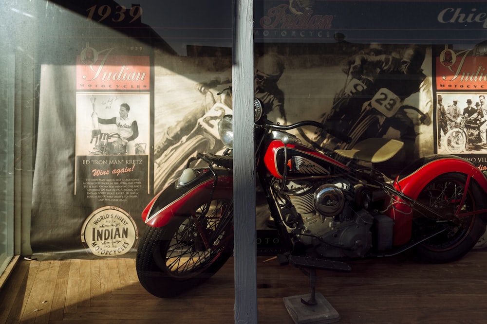 ガラス窓の横に駐車した黒と赤のオートバイ