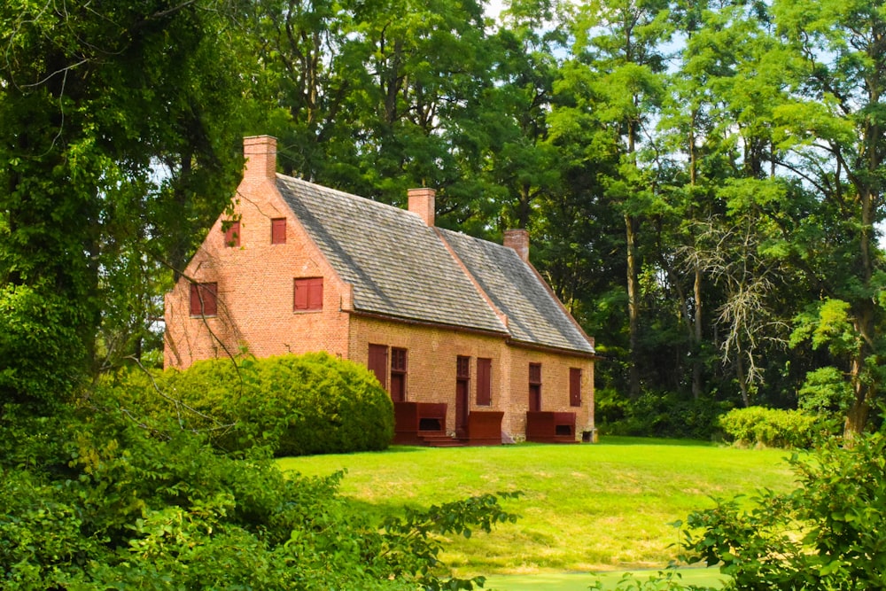 brown brick house surrounded by green trees during daytime