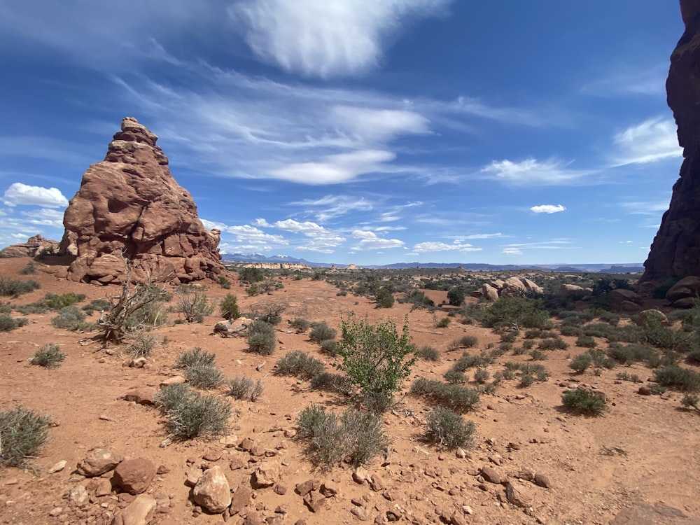 brown rock formation under blue sky and white clouds during daytime