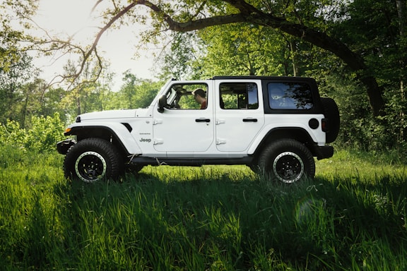 white suv parked on green grass field during daytime
