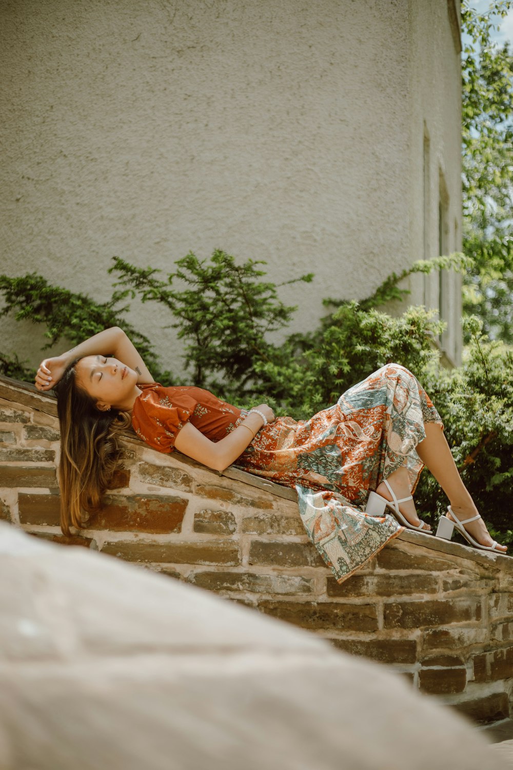 woman in orange dress lying on concrete stairs