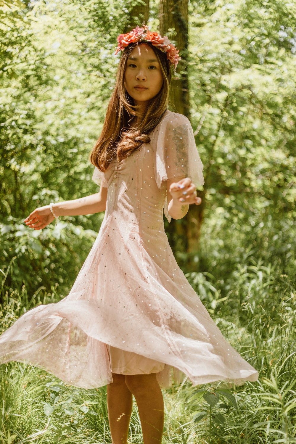Una niña con un vestido de pie en el bosque