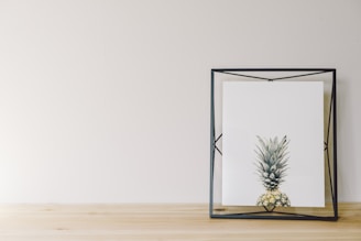 A minimalist art print displayed in a clean, white frame on a light wall.