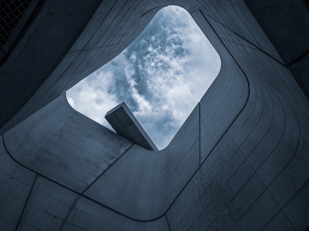 worms eye view of gray concrete building under blue and white sunny cloudy sky