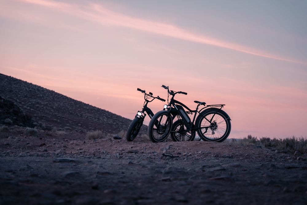 Un par de bicicletas que están sentadas en la tierra