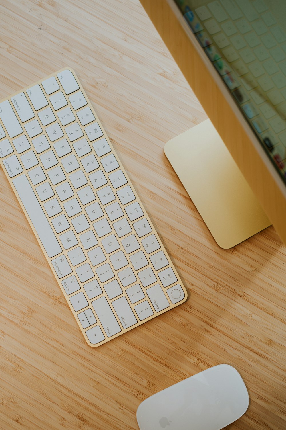 茶色の木のテーブルの上の白いリンゴのキーボード