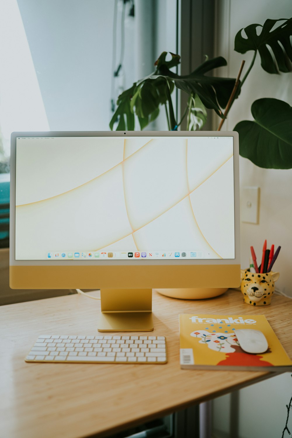 iMac plateado sobre mesa blanca