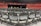 Rows of empty black chairs are neatly arranged in a large indoor arena with red stadium seating. A stage is set up at the front with a podium, potted plants, and flags. The words 'Class of' are partially visible on a sign, suggesting a graduation ceremony setting.