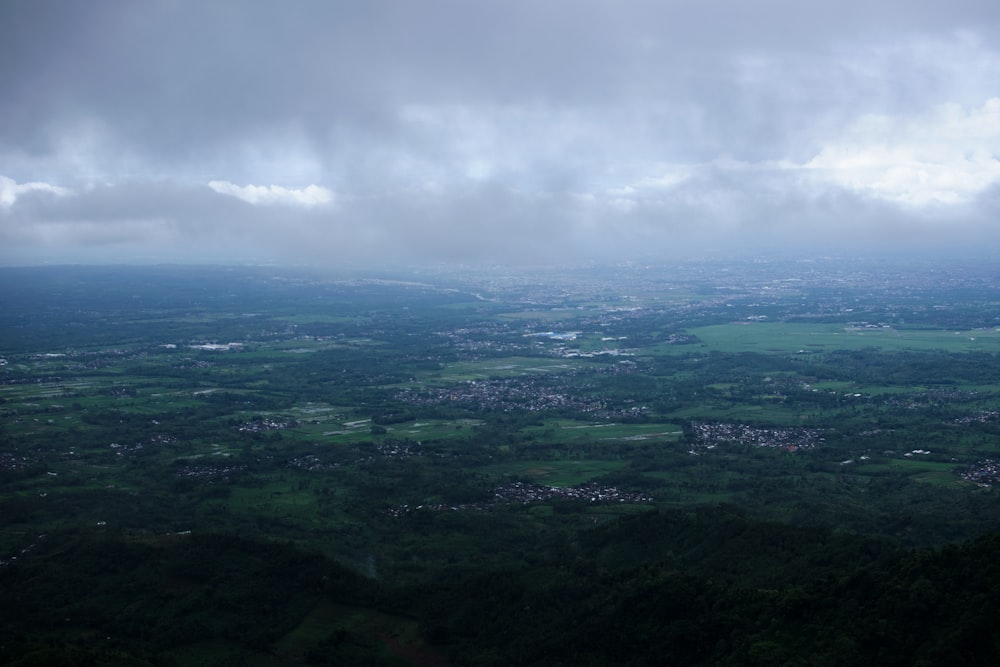 aerial view of green mountains under cloudy sky during daytime