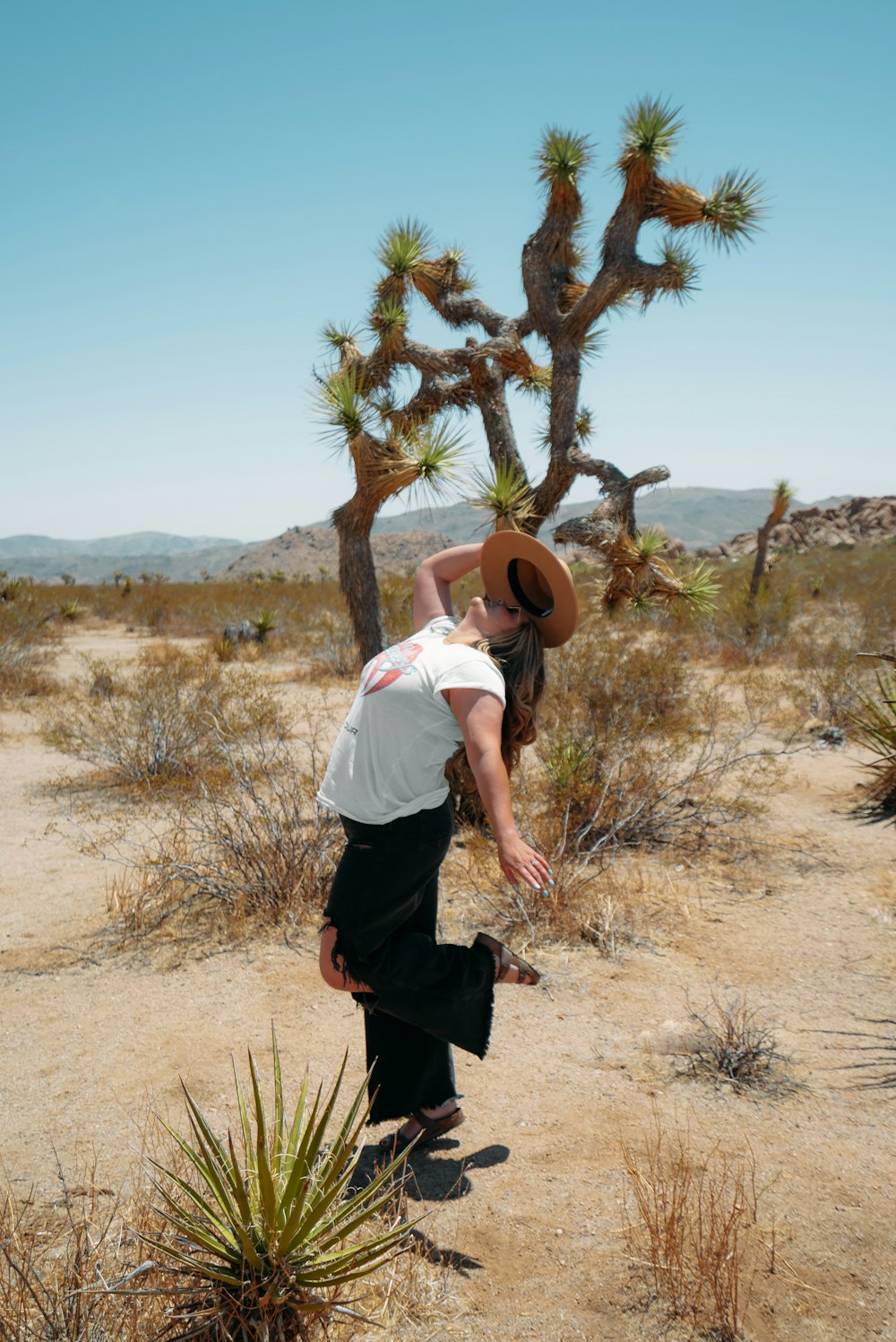 man in white shirt and black pants standing on brown grass field during daytime