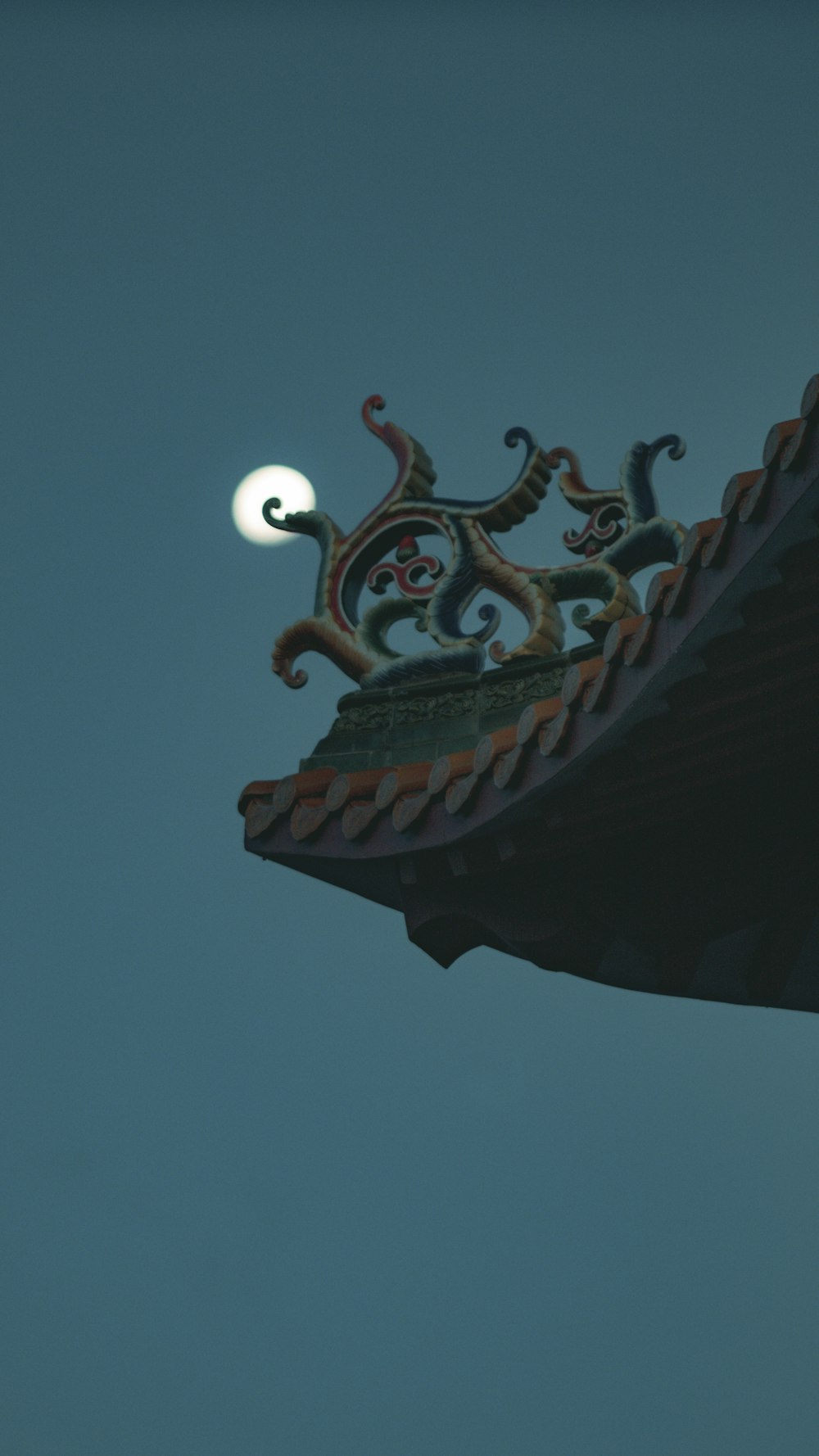 a roof with a moon in the background