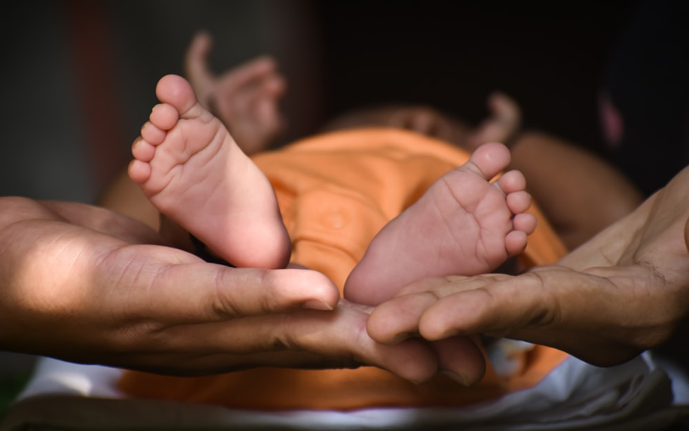 person holding babys feet