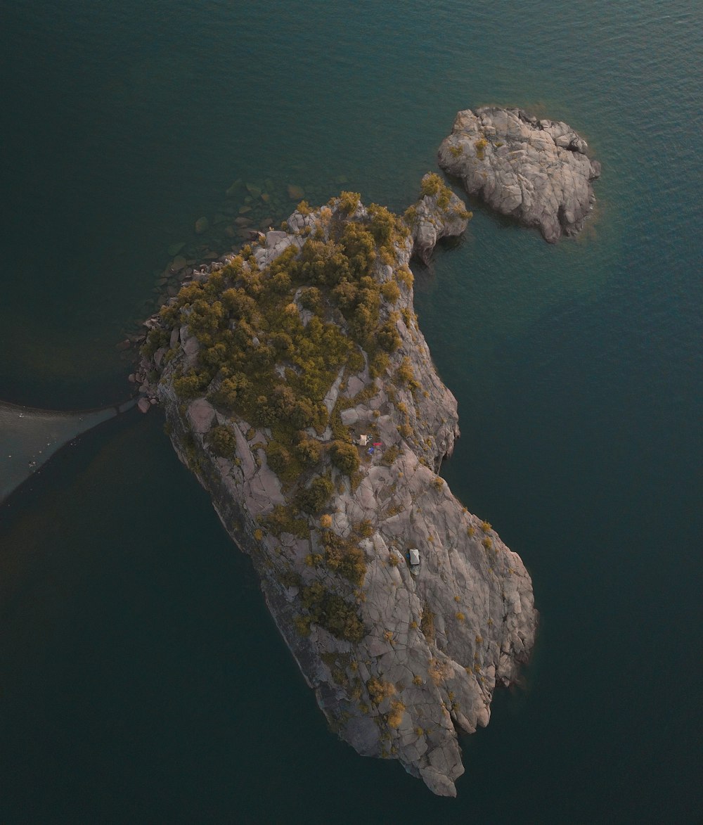 brown rock formation on body of water during daytime