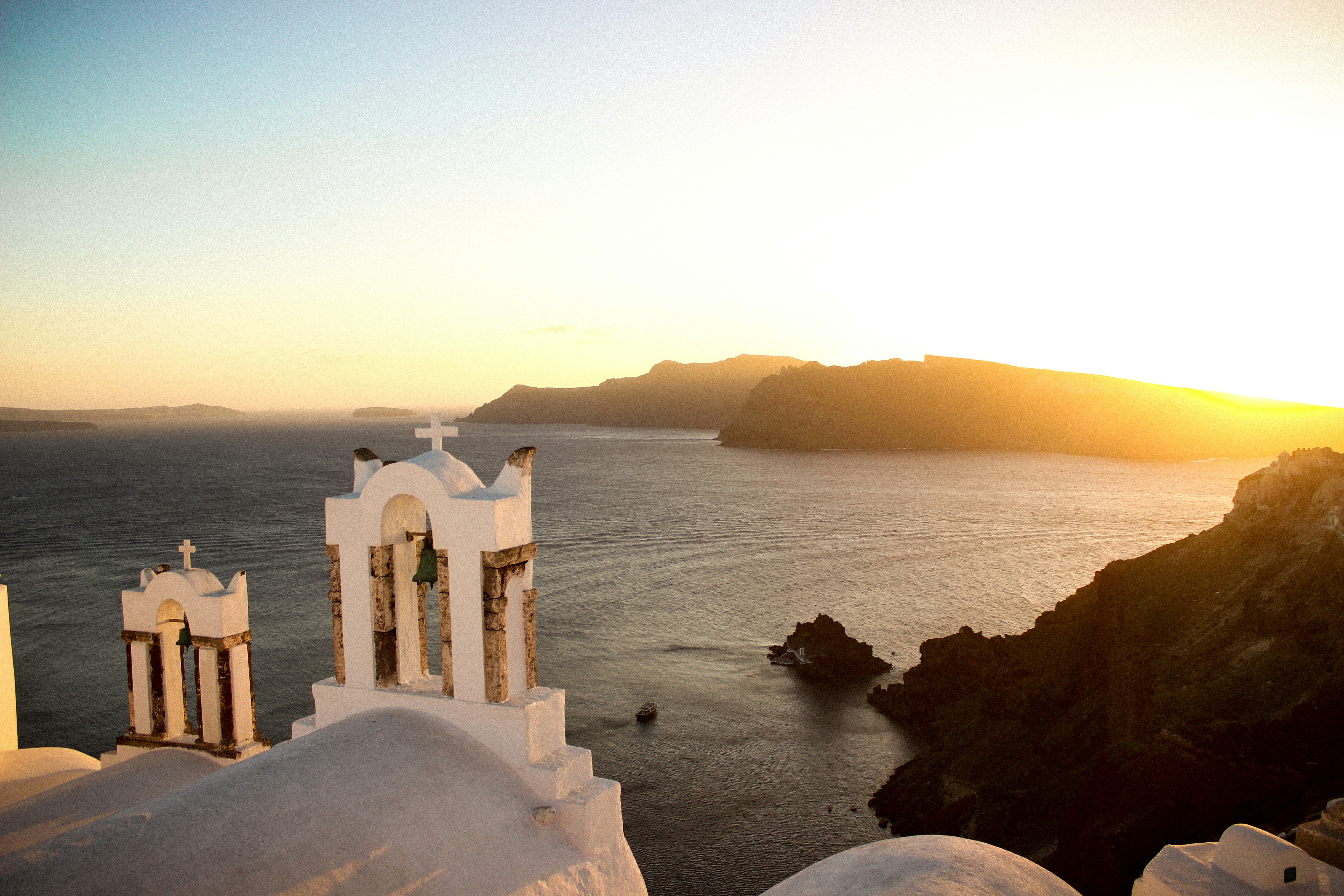 white concrete building on top of mountain near body of water during daytime, Sunset in Santorini Greece.