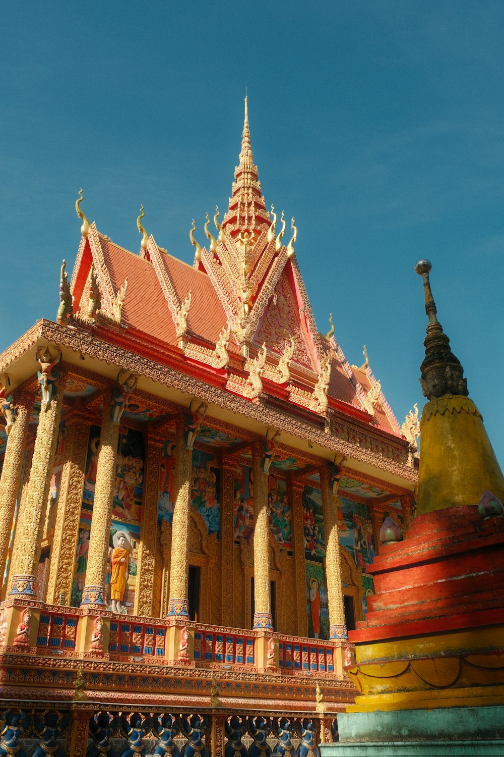 a large building with a red roof and gold trim