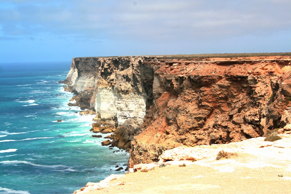 brown rock formation near body of water during daytime