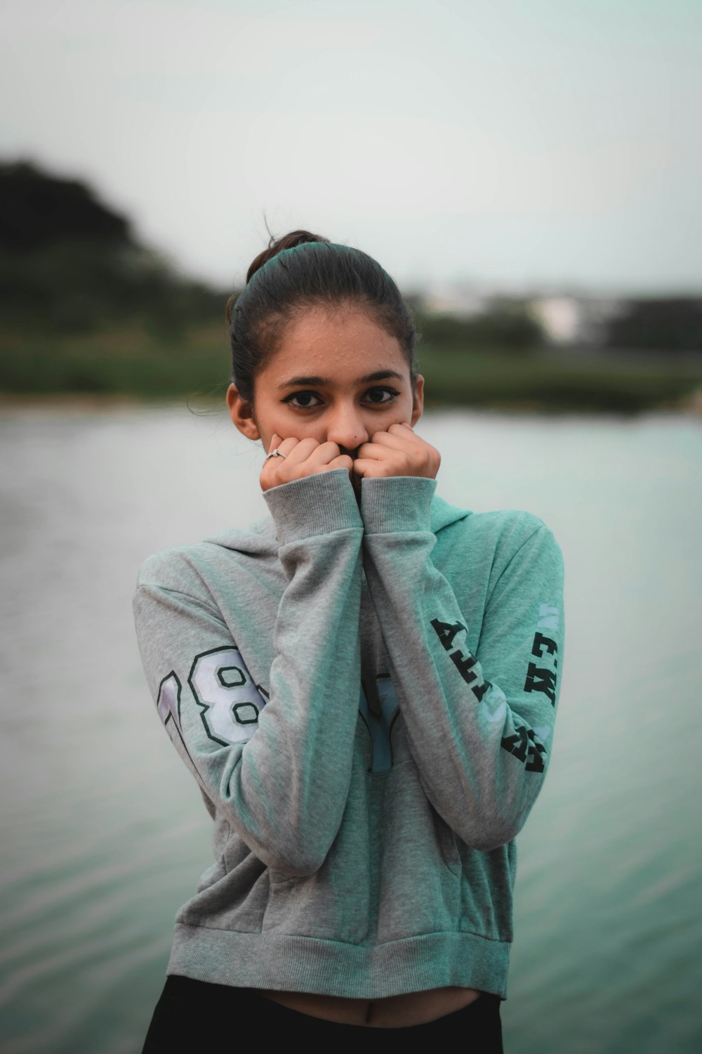 boy in gray hoodie covering his face with his hand