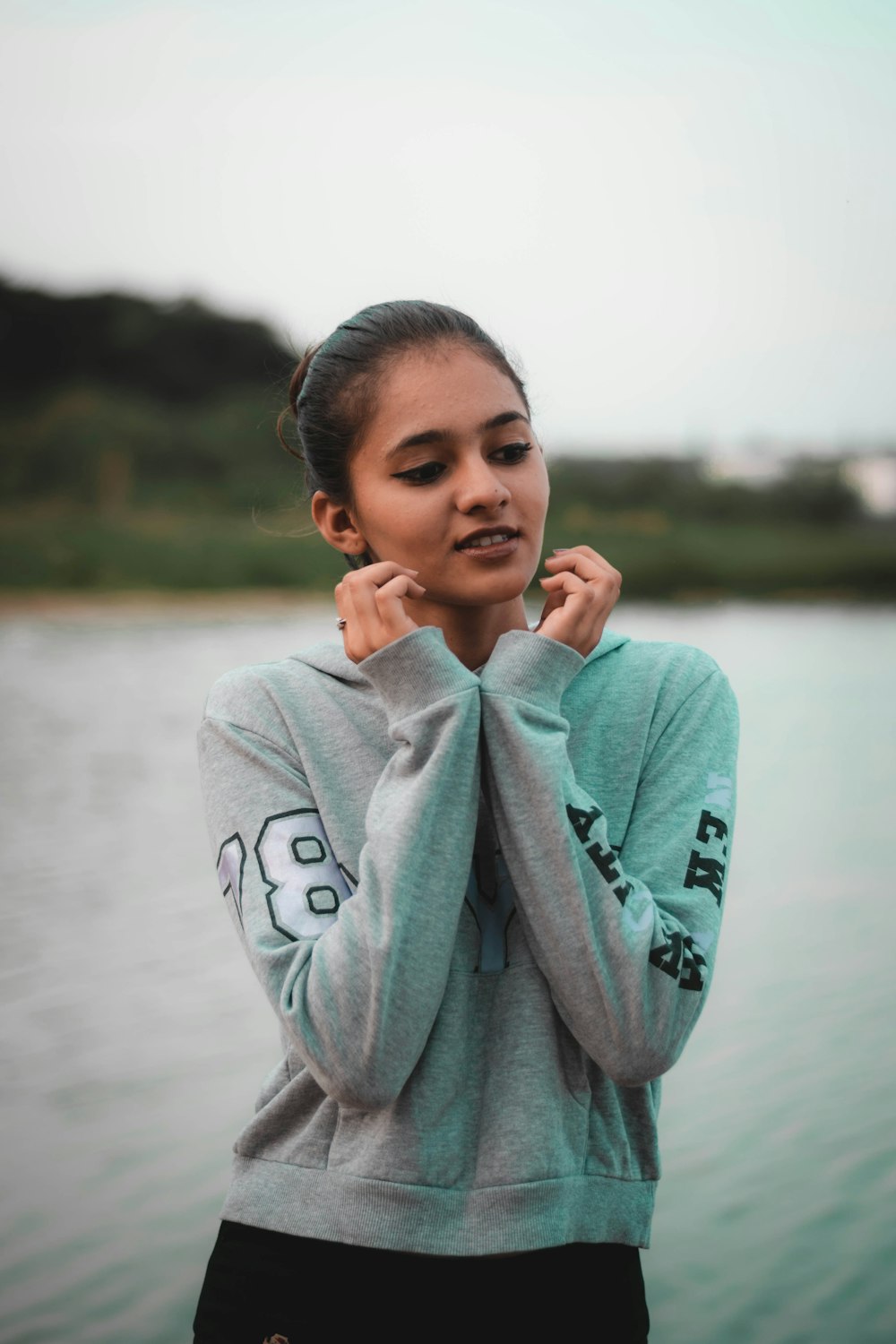 a woman standing next to a body of water