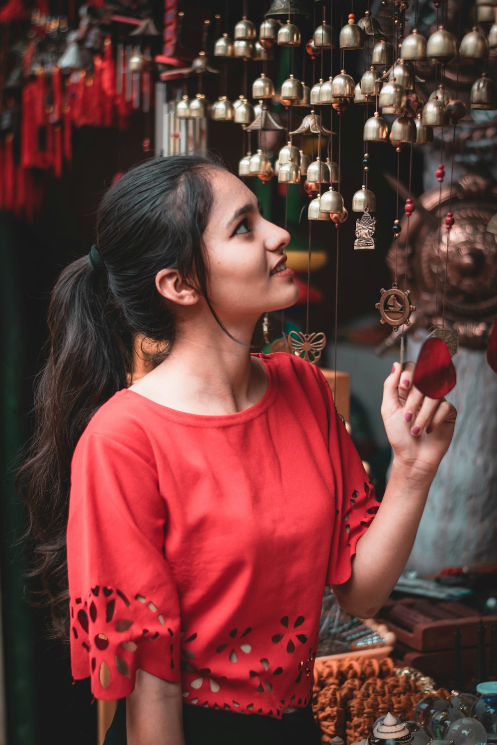 menina no pescoço vermelho da tripulação camisa de manga longa segurando enfeites vermelhos