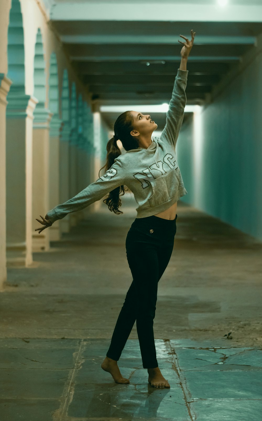 a woman is dancing in a long hallway