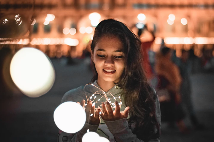 a young girl holding a glass ball in her hands