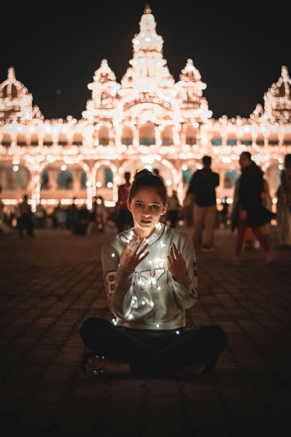 a woman sitting on the ground in front of a building