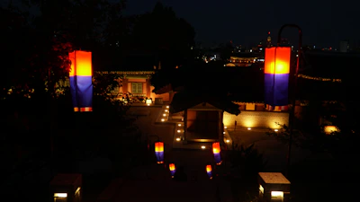 Evening view of the guest house courtyard lit by warm lanterns.