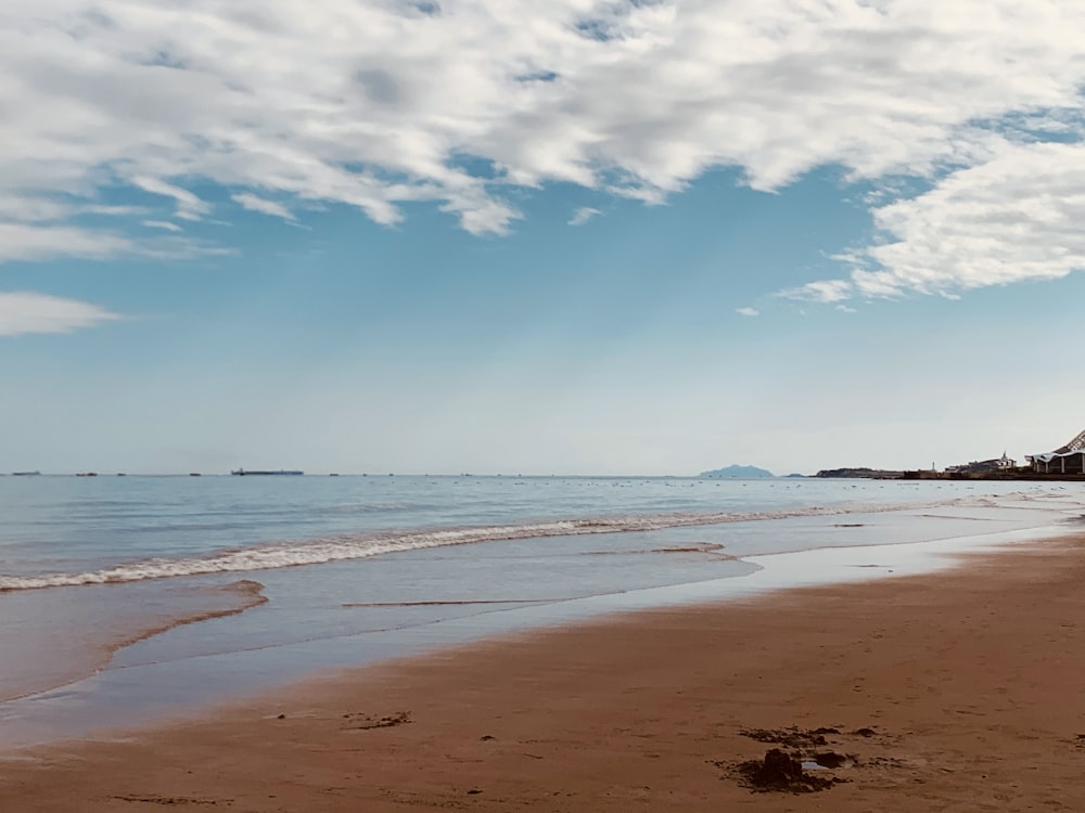 a person walking on a beach next to the ocean