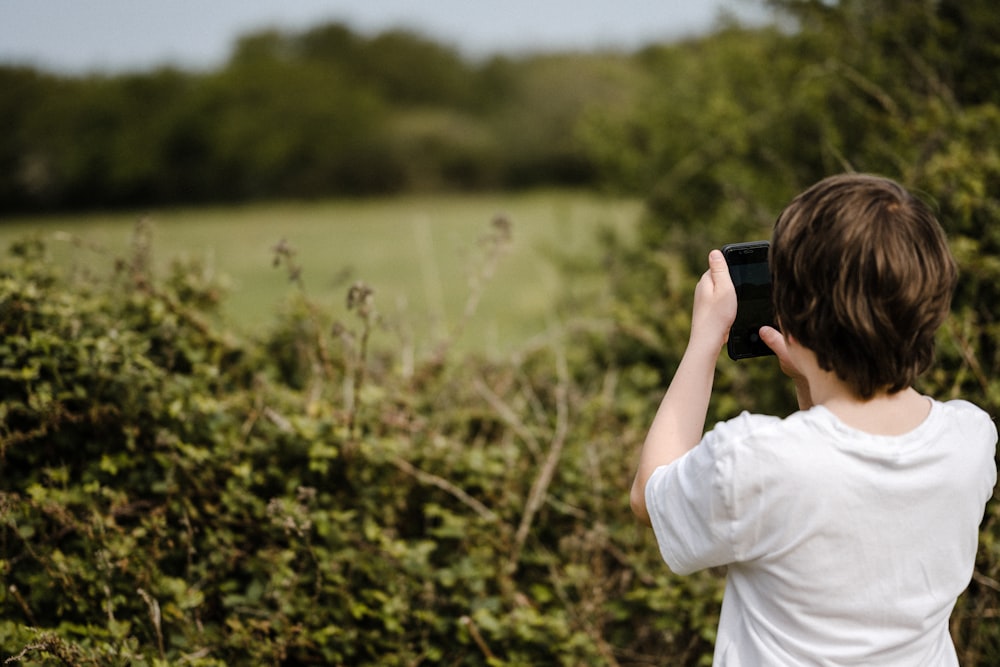 Un jeune garçon prenant une photo avec son téléphone portable