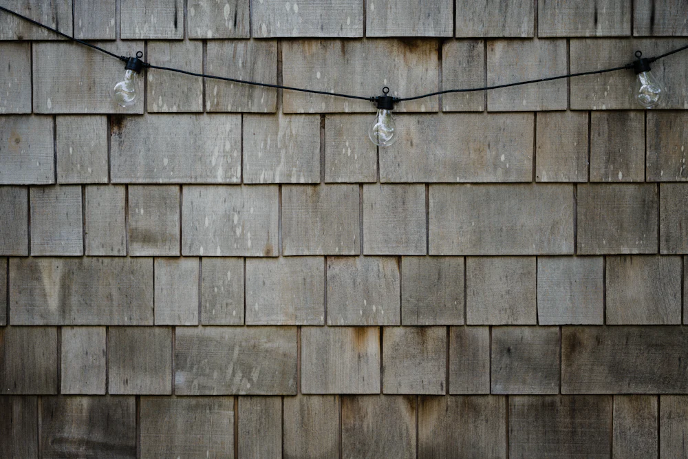 Warm string lights strung across a panelled wooden wall.