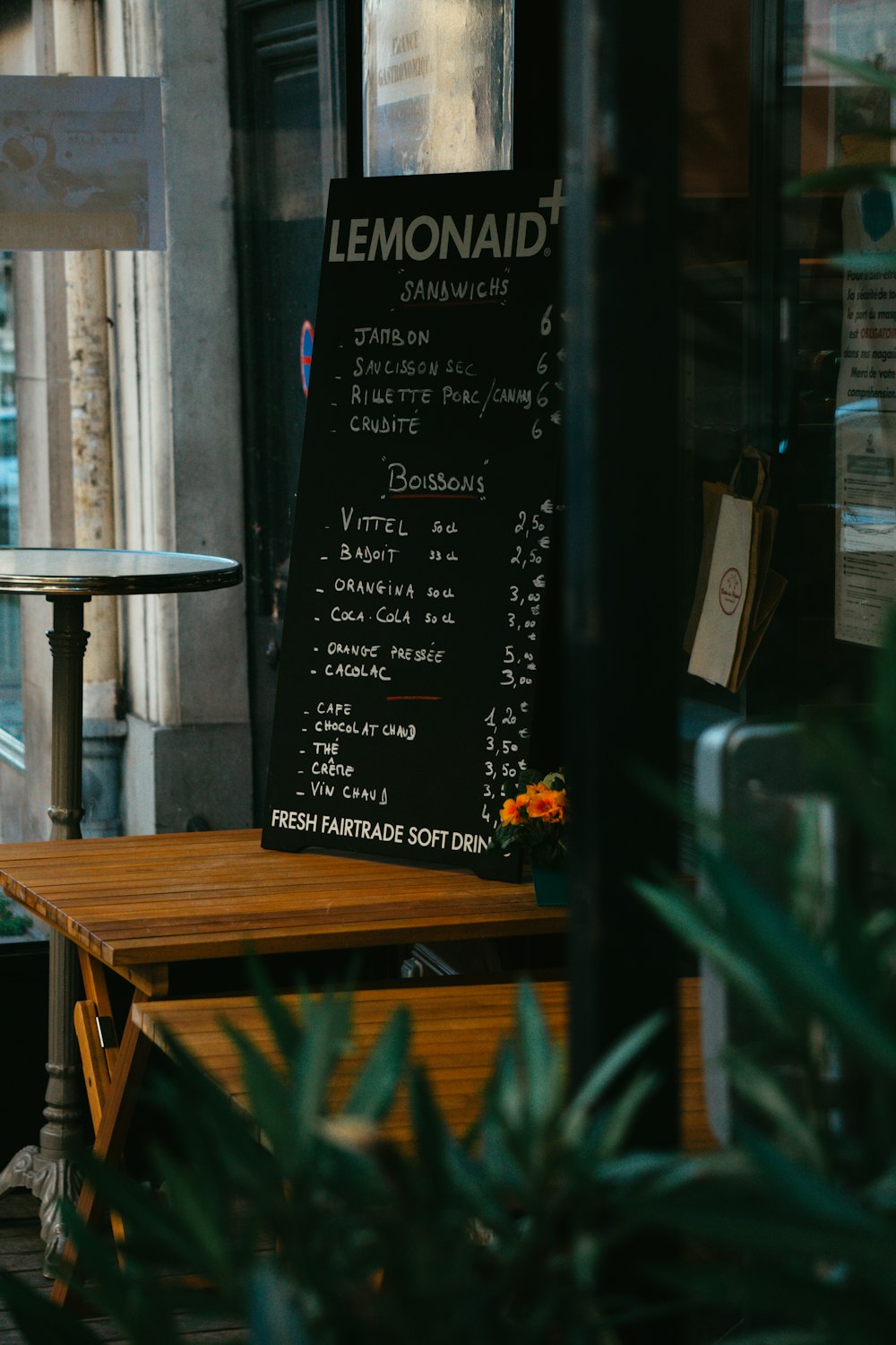 a menu on a wooden table outside of a restaurant