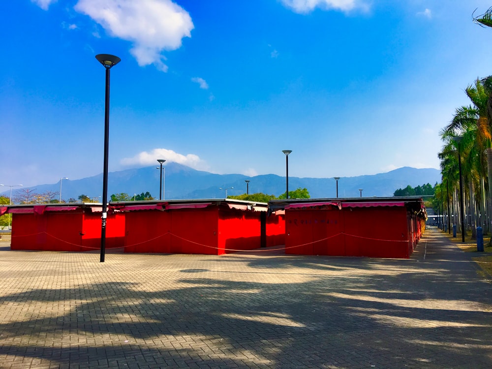 a row of red benches sitting on top of a sidewalk