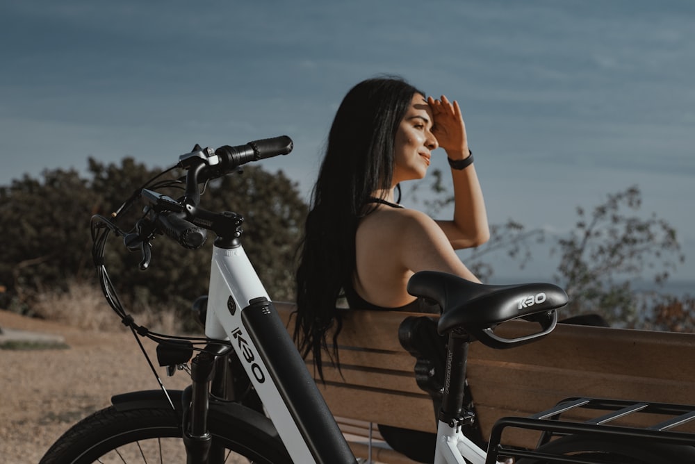 woman in black tank top riding on black bicycle during daytime