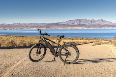 black and gray hardtail mountain bike on brown sand near body of water during daytime